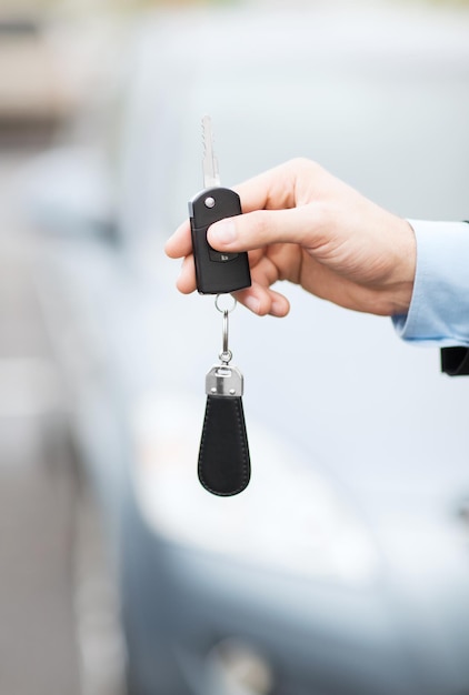 concept de transport et de propriété - homme avec clé de voiture à l'extérieur