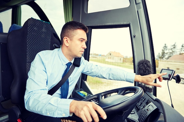 Photo concept de transport, de transport, de navigation et de personnes - chauffeur de bus entrant l'adresse du navigateur gps