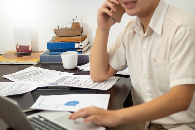 Concept de travail à distance Homme indépendant utilisant un ordinateur portable et parlant avec le client tout en travaillant à la maison