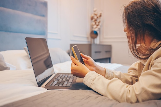 Concept de travail à domicile avec une femme travaillant sur un téléphone intelligent et un ordinateur portable