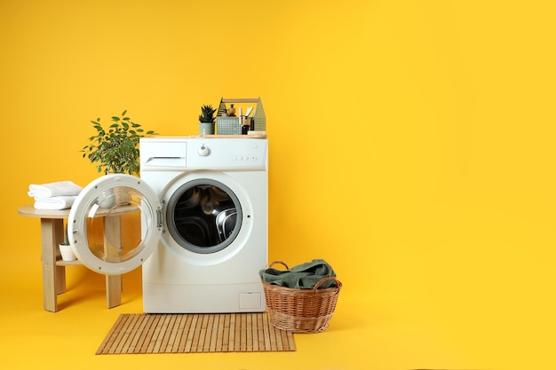 Concept de travaux ménagers avec machine à laver sur fond jaune