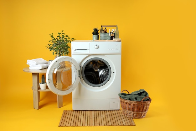 Concept de travaux ménagers avec machine à laver sur fond jaune
