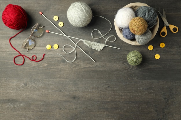 Concept de tricot avec des boules de fil sur une table en bois gris