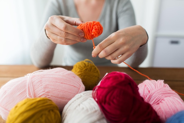 concept de tricot, de personnes et de travaux d'aiguille - femme tirant le fil en boule