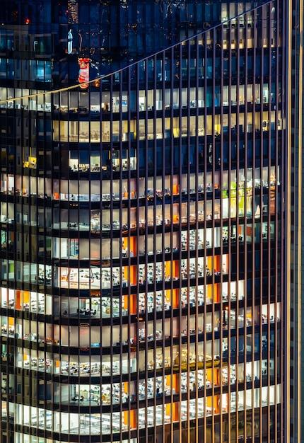 Concept urbain de travail tardif, façade de fenêtre de gratte-ciel de bureau de centre d'affaires dans la nuit