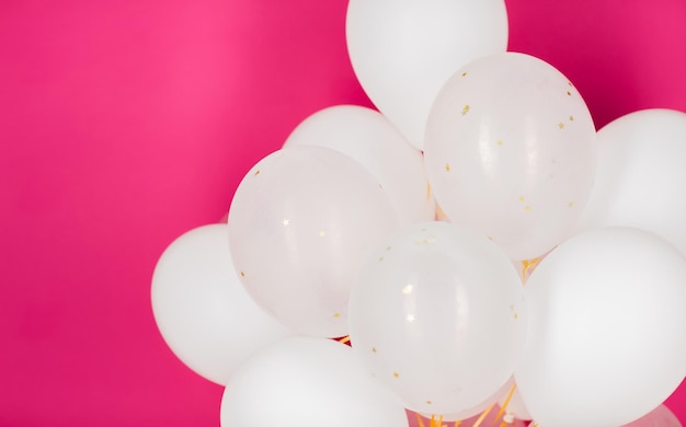 concept de vacances, d'anniversaire, de fête et de décoration - gros plan de ballons d'hélium blancs gonflés sur fond rose