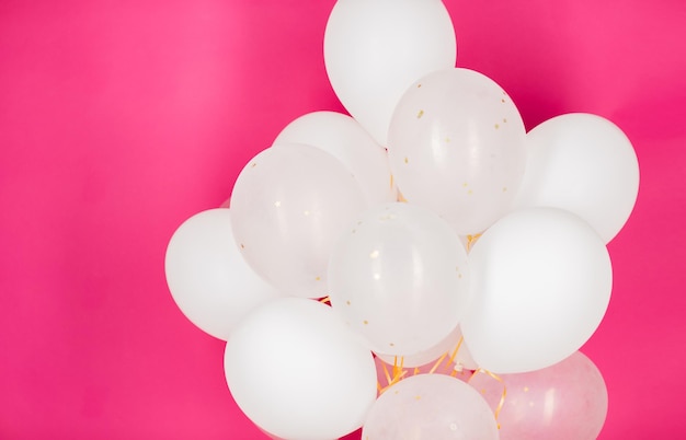 concept de vacances, d'anniversaire, de fête et de décoration - gros plan de ballons d'hélium blancs gonflés sur fond rose