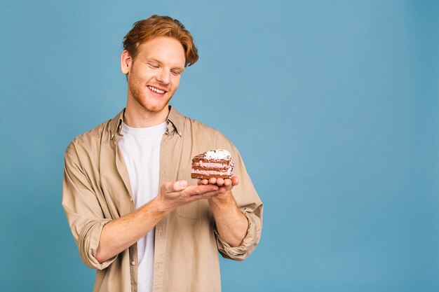 concept de vacances d'anniversaire ! portrait de joyeux jeune homme heureux tenant un gâteau d'anniversaire