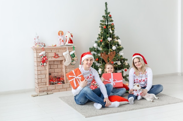 Concept de vacances et de cadeaux - Portrait d'une famille heureuse ouvrant des cadeaux au moment de Noël.