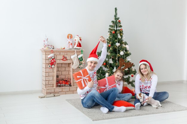 Concept de vacances et de cadeaux - Portrait d'une famille heureuse ouvrant des cadeaux au moment de Noël.