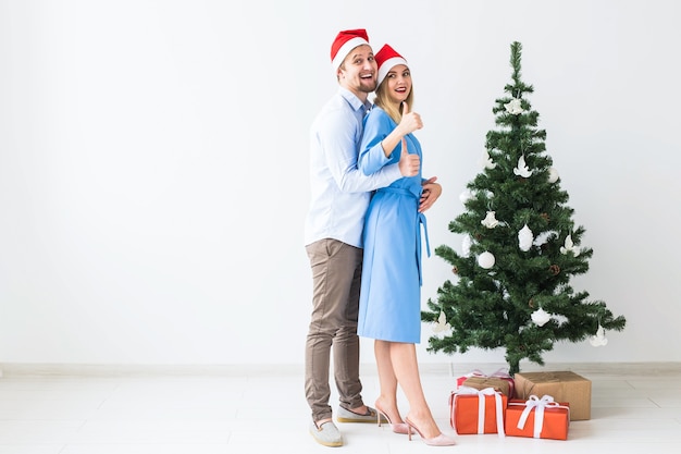 Concept de vacances et de célébration - Jeune couple célébrant Noël à la maison.