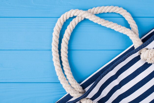 Concept de vacances d'été. Haut au-dessus de vue aérienne photo de sac rayé bleu isolé sur fond de bois bleu