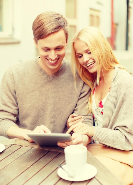 concept de vacances d'été, de rencontres et de technologie - couple regardant un tablet pc dans un café de la ville