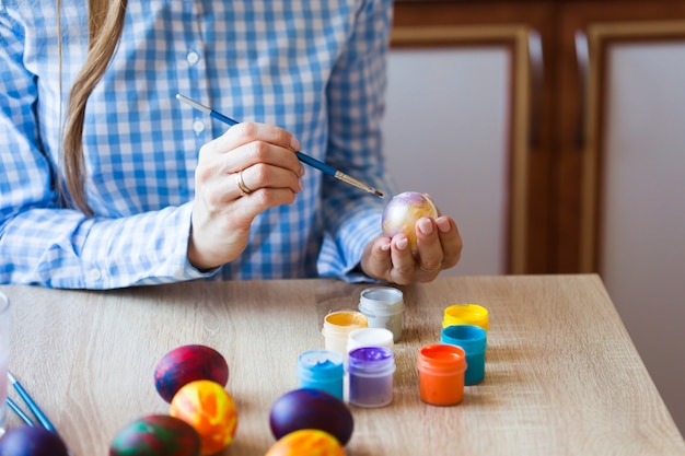 Concept de vacances, fait main et création - Fille s'appuie sur l'oeuf de Pâques, gros plan.