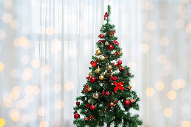 concept de vacances, de fête et de maison - arbre de noël dans le salon au-dessus du rideau de la fenêtre