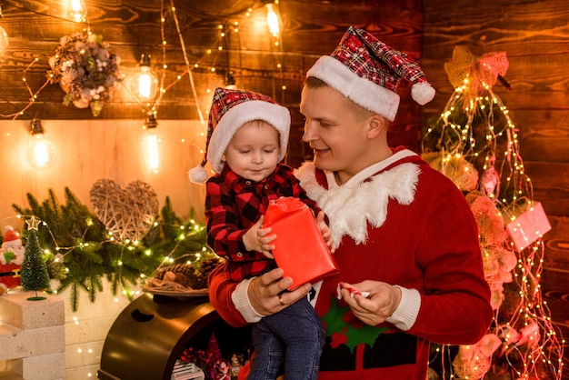 Concept de vacances d'hiver. Ambiance magique pour des vacances en famille. La joie de la paternité. Profitez de chaque instant avec son fils. Passez des vacances ensemble. L'amour de la famille. Père et fils fêtent Noël à la maison