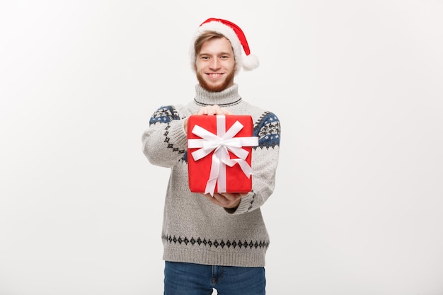 Concept de vacances jeune bel homme donnant un cadeau rouge à la caméra