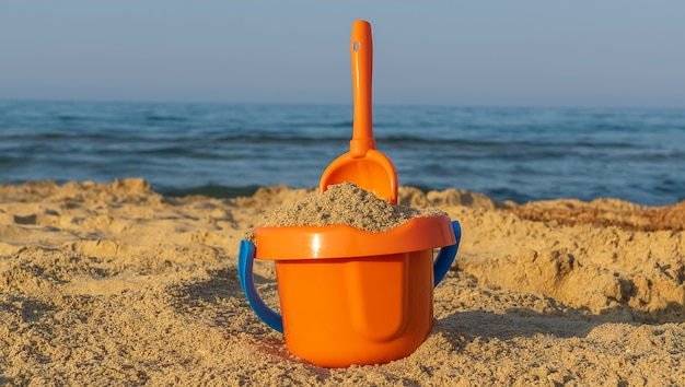 Photo concept de vacances. jouets de plage pour enfants sur le sable.