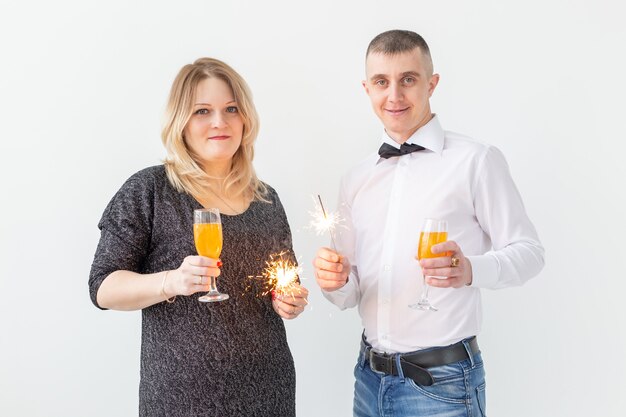 Concept de vacances, Noël, Saint-Valentin et nouvel an - La femme et l'homme célèbrent et tiennent du vin dans un verre sur fond blanc.