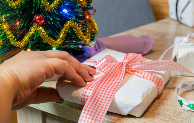 Concept de vacances et de personnes de Noël: mains de femmes préparant des cadeaux de Noël