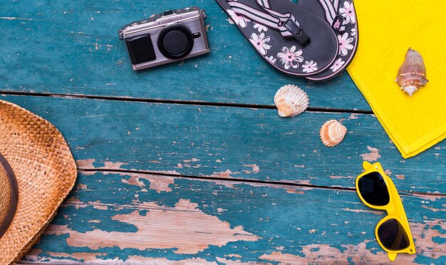 Concept de vacances Table en bois vintage avec accessoires de vacances Chapeau de paille lunettes de soleil coquilles et tongs Copier l'espace