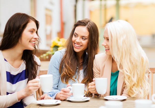 concept de vacances et de tourisme - belles filles buvant du café au café