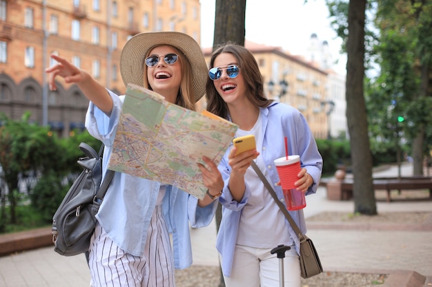 Photo concept de vacances et de tourisme - belles filles à la recherche d'une direction dans la ville.