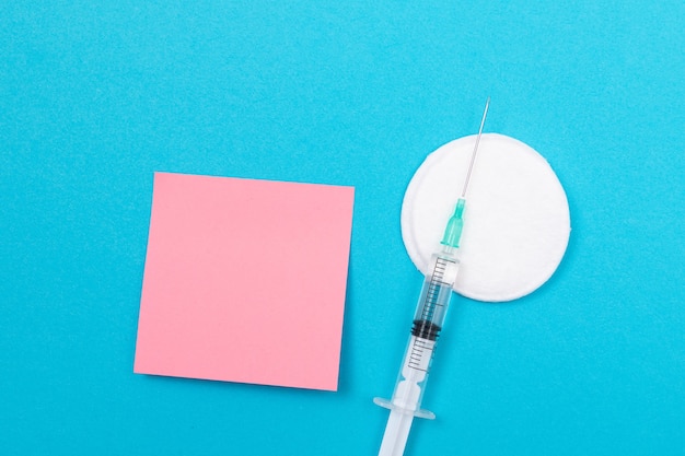Concept de vaccination ou de revaccination une seringue médicale sur table bleue