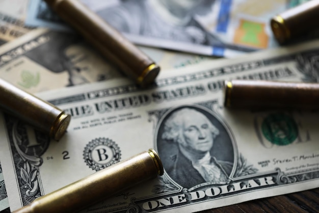 Concept de vente illégale d'argent criminel Dollars américains et balle pour cartouches d'armes à feu sur fond