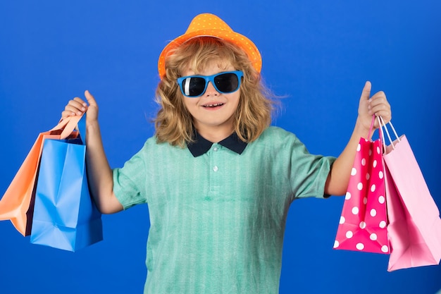 Concept de vente et de remise Enfant avec des sacs à provisions Enfant en chapeau et chemise à la mode