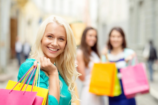 concept de vente, de shopping, de tourisme et de gens heureux - belle femme avec des sacs à provisions dans le ctiy