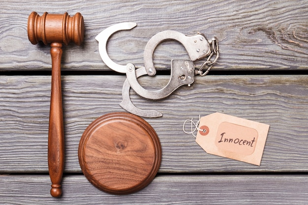 Concept de verdict innocent. Gavel et menottes sur un bureau en bois.