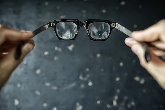 concept de vision de lunettes, l'homme tient des lunettes dans sa main.