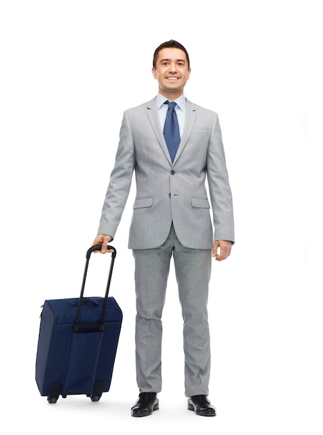 concept de voyage d'affaires, de voyage, de bagages et de personnes - homme d'affaires heureux en costume avec sac de voyage