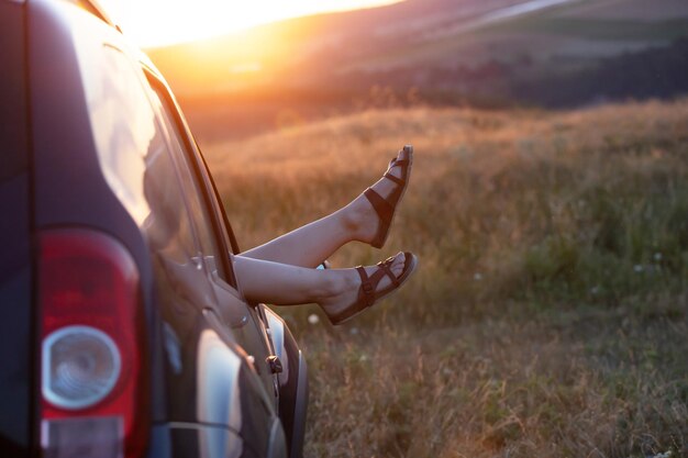 Concept de voyage d'été avec les jambes d'une femme et d'une voiture