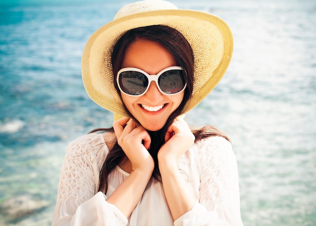 Concept de voyage - femme heureuse au chapeau sur la plage