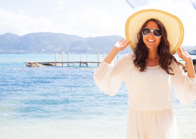 Concept de voyage Femme heureuse au chapeau sur la plage