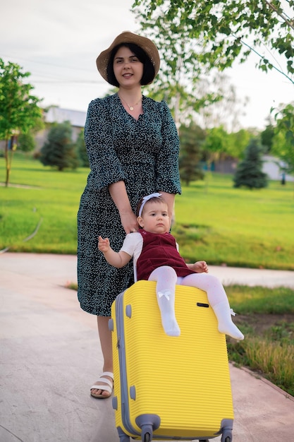 Concept de voyage mère et fille avec une valise se préparent pour un voyage un enfant est assis