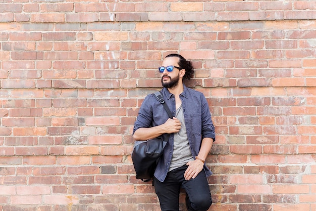 concept de voyage, de tourisme, de style de vie et de personnes - homme souriant heureux avec sac à dos debout au mur de la rue de la ville