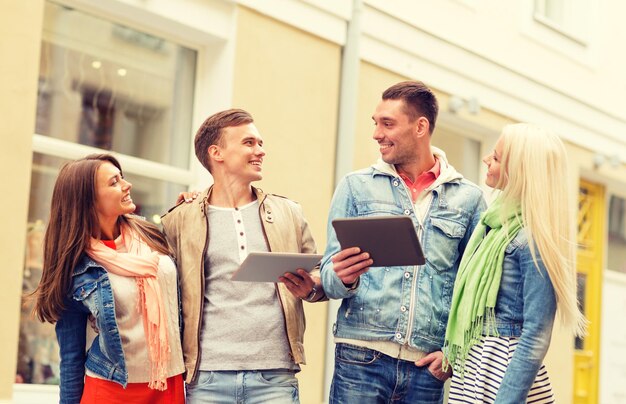 concept de voyage, de vacances, de technologie et d'amitié - groupe d'amis souriants avec des ordinateurs tablettes dans la ville