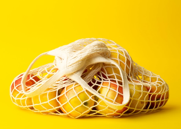 Concept zéro déchet. Pommes dans un sac de ficelle sur fond jaune. Pas de sacs en plastique dans les supermarchés et les magasins concept