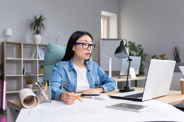 Concepteur d'architecte belle jeune femme asiatique portant des lunettes travaillant à l'ordinateur de bureau et