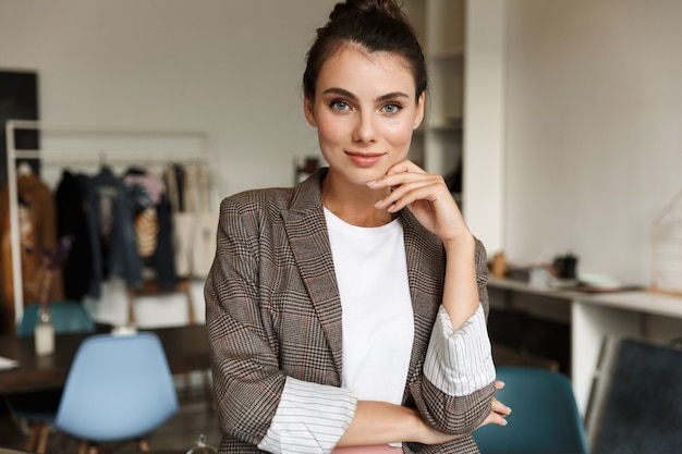 Concepteur de jeune femme séduisante et confiante debout au bureau