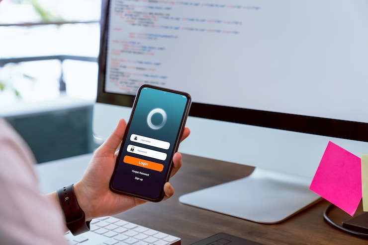 Photo le concepteur tient le smartphone et les applications de conception avec des performances de test avant de les envoyer aux clients. concept de système de travail en ligne.