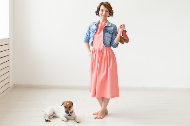 Concepteur de vêtements, personnes, concept pour animaux de compagnie - jeune femme en robe et veste en jean avec jack russell