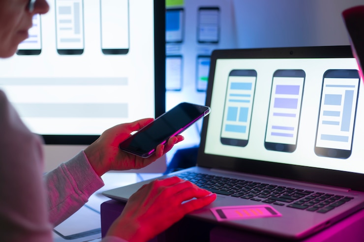 Photo les concepteurs d'interfaces web développent une application pour smartphones. l'équipe de créateurs travaille sur une interface avec les téléphones portables.