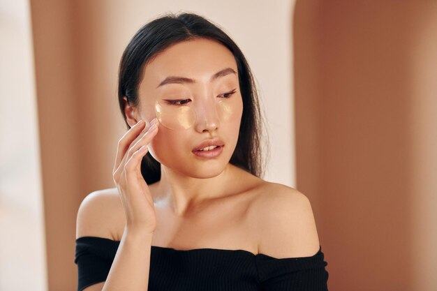 Conception de la beauté Jeune femme asiatique sérieuse debout à l'intérieur