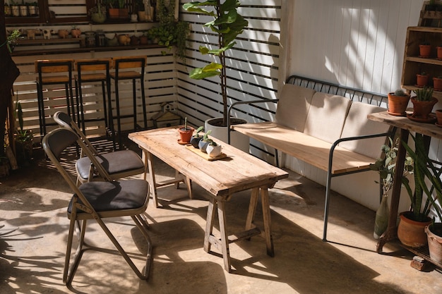 Conception de café rétro avec chaise de table en bois et vase de cactus décorer sur cour