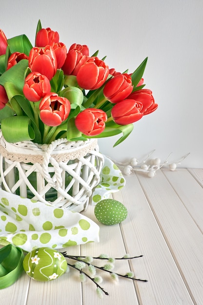 Conception de carte de voeux de Pâques avec bouquet de tulipes rouges sur ressort clair avec des décorations de Pâques vert clair,