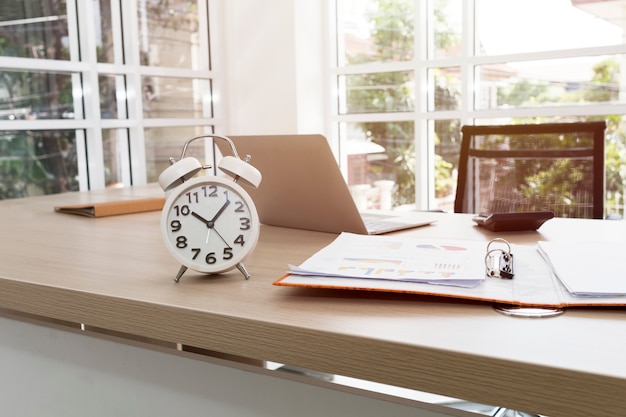 La conception du lieu de travail dans la salle des officiers comporte une table, une horloge, un ordinateur portable près de la fenêtre.